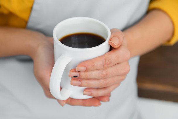 cropped view of woman holding white cup of coffee  - Фото, изображение