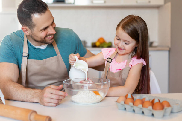Papà e piccola figlia making pasta cuocere torta in cucina - Foto, immagini