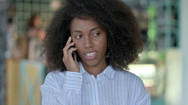 Iloinen nuori afrikkalainen nainen puhuu älypuhelimella - Valokuva, kuva