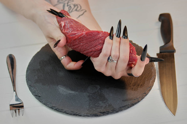 Womans twisting raw veal meat. - Foto, imagen