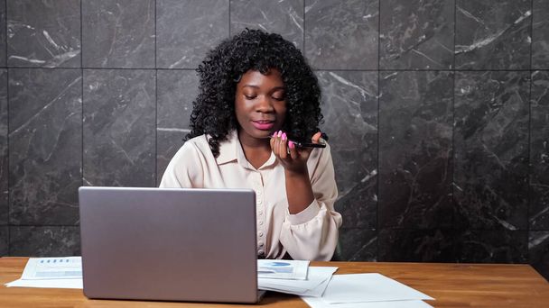 Afroamerikanische Geschäftsfrau telefoniert beim Anblick von Grafiken - Foto, Bild