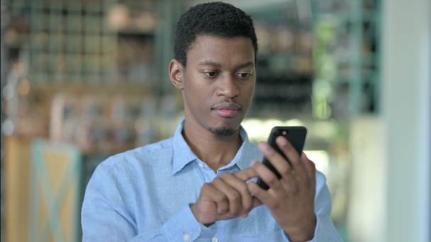 Pozitív fiatal afrikai férfi portréja okostelefonnal  - Fotó, kép