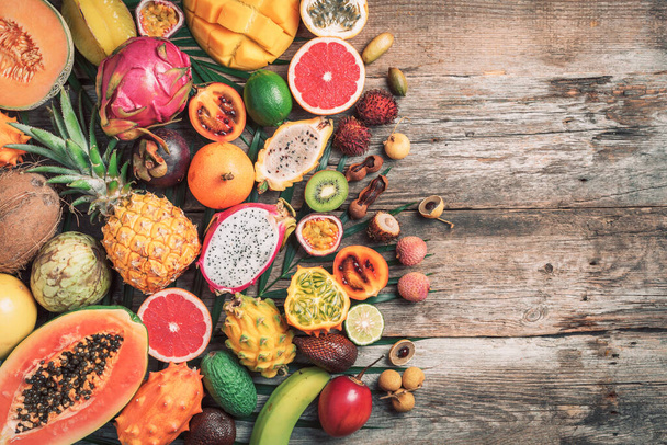 Assortment of tropical fruits concept. Exotic fruits - pineapple, papaya, mango, annona, banana, pitahaya, kiwano, african horned melon, tamarillo fruit, granadilla, salak, snake fruit, maracuya - Foto, imagen