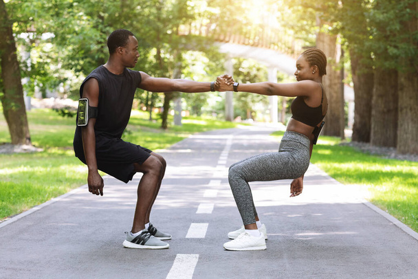 Teamwork In Sport. Active Black Couple Exercising Together In City Park - Foto, afbeelding