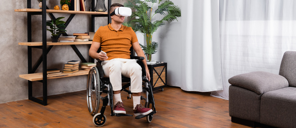 disabled man in casual clothes gaming in vr headset while sitting in wheelchair, banner - Fotó, kép