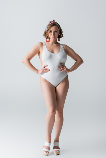 full length of overweight young woman in swimwear posing with hands on hips on white - Fotografie, Obrázek