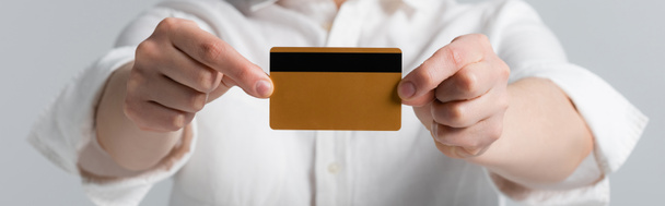 przycięty widok plus rozmiar kobieta posiadająca kartę kredytową odizolowany na szary, baner - Zdjęcie, obraz