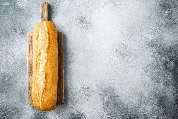 Çıtır Fransız baget ekmeği, gri arkaplanda, üst görünüm düz metin için kopyalama alanı ile yatar - Fotoğraf, Görsel