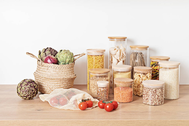 Assortimento di cereali, cereali e pasta in barattoli di vetro e verdure su tavola di legno - Foto, immagini