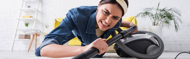 Angry woman cleaning carpet with vacuum cleaner, banner  - Фото, зображення