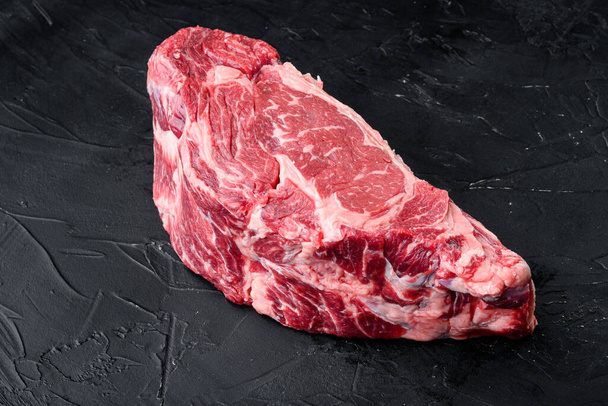生の新鮮な肉Ribeyeステーキの遠近黒アンガスプライム肉セット,黒石の背景に,テキストのためのコピースペースと - 写真・画像