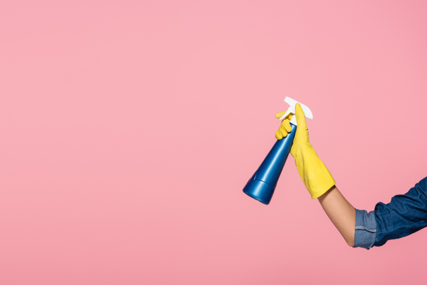 Vista cortada da mulher em luva de borracha segurando garrafa de detergente isolado em rosa - Foto, Imagem