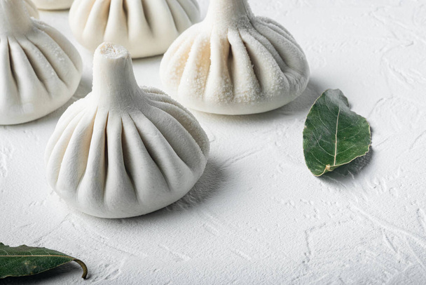 Stuffed dumplings, manti of dough and minced  set, on white stone  surface, with copy space for text - Photo, Image
