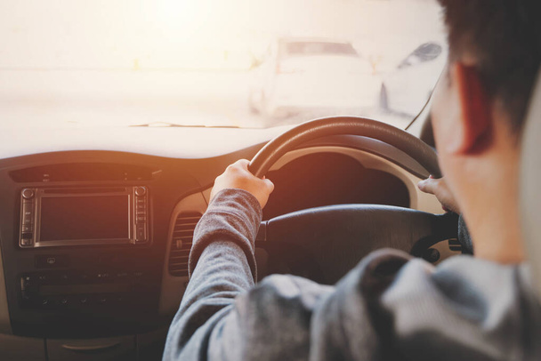 Man driving car, hand on steering wheel, looking at the road ahead. - Фото, изображение