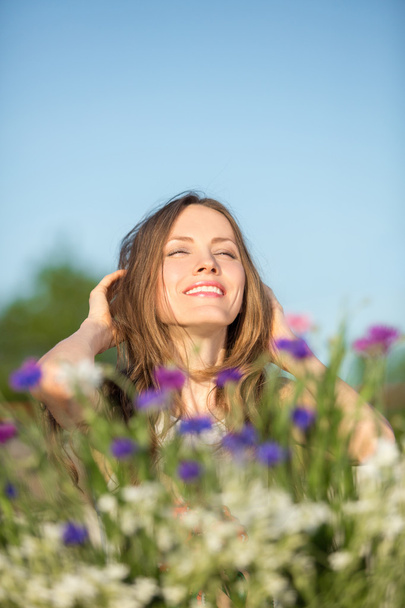 Happy young woman in flower field - Φωτογραφία, εικόνα
