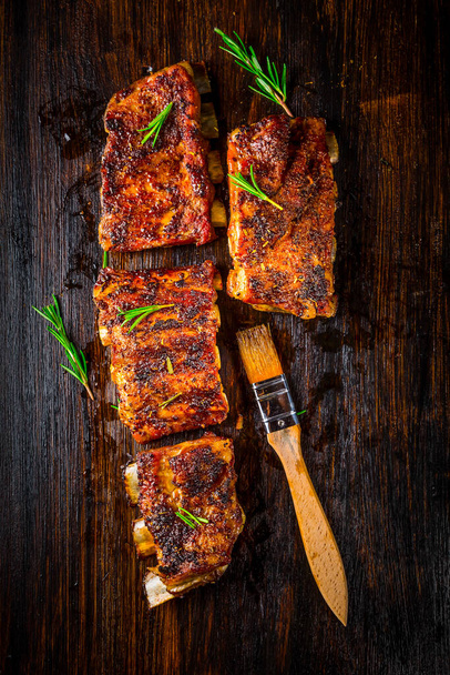 Hot spare ribs with herbs and spices on black wooden background - Valokuva, kuva