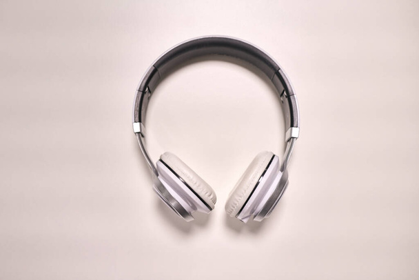 Крупним планом сучасні металеві навушники на білому тлі
 - Фото, зображення