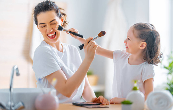 Happy loving family. Mother and daughter are doing make up and having fun. - Zdjęcie, obraz