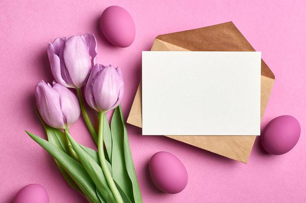 Easter holiday greeting card mockup with colored eggs and tulips on pink - Fotoğraf, Görsel