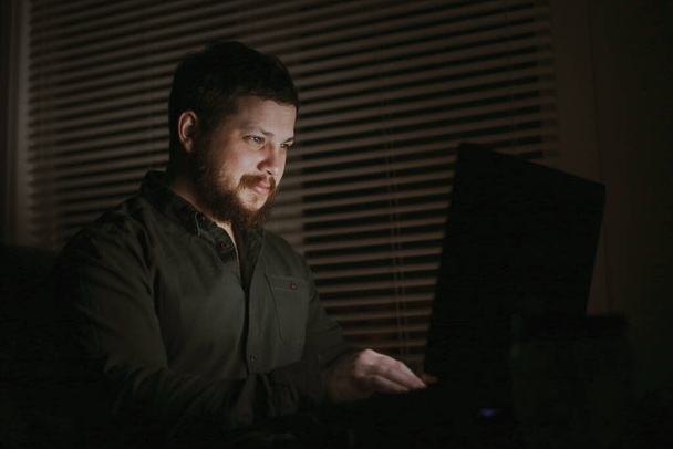 Портрет европейского бизнесмена, работающего с ноутбуком вечером. - Фото, изображение