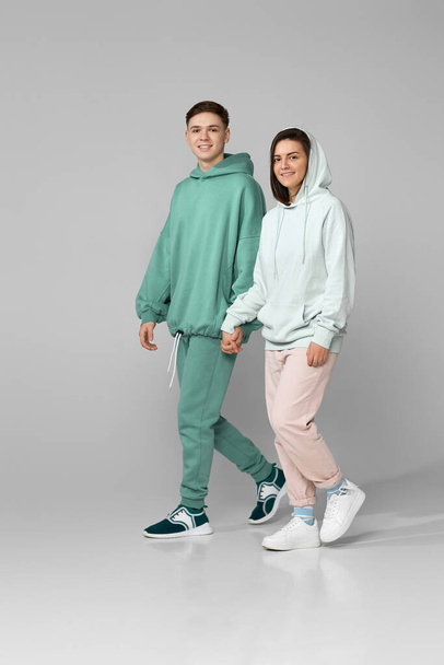 young couple wearing mint green casual hoodie - Zdjęcie, obraz
