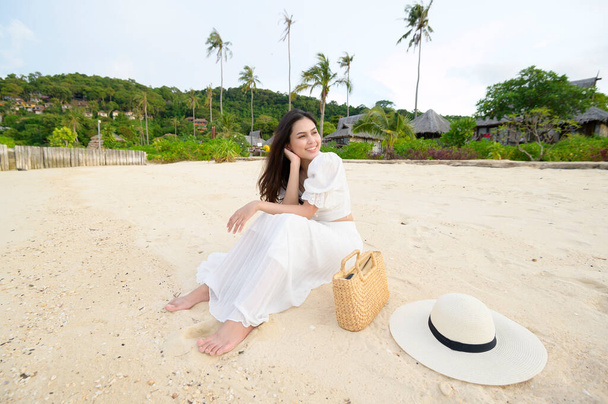 A happy beautiful woman in white dress enjoying and relaxing on the beach, Summer and holidays concept - Photo, Image