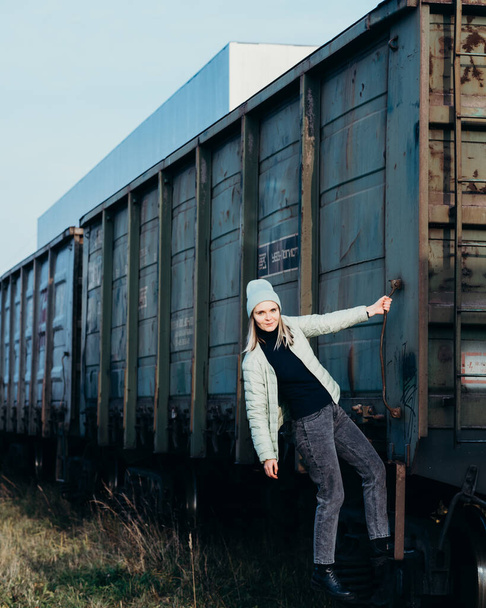 young woman girl hanging on the wagon of a freight freight train green. transportation - 写真・画像