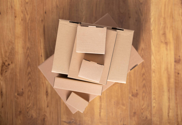 Stack of cardboard box on floor laminate background. Empty box case top view. Moving or relocation concept - Foto, Imagen