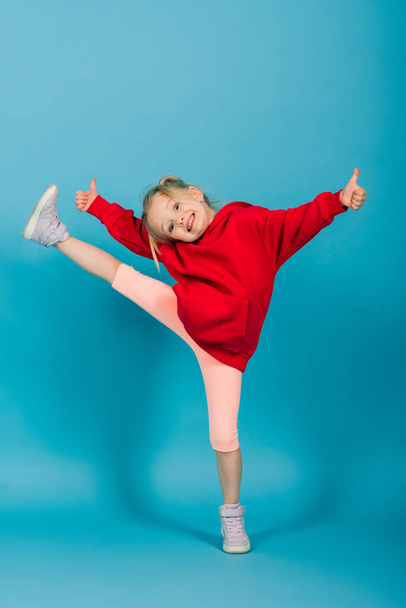 Porträt eines fröhlichen Mädchens, das vor Studiohintergrund springt und tanzt - Foto, Bild
