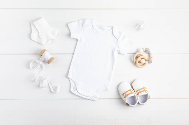 エコフレンドリーな赤ちゃんのアクセサリーと有機綿で作られた白い幼児のボディスーツのモックアップ - 写真・画像