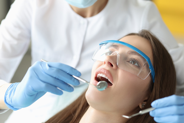 Dentist examines woman oral cavity in office closeup - Foto, Bild