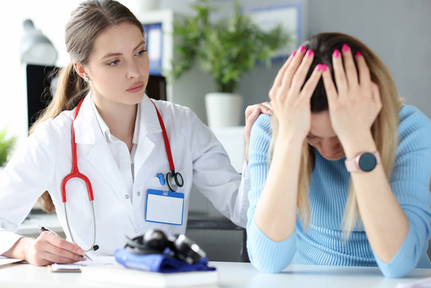 Docteur calme une femme bouleversée après un examen médical - Photo, image