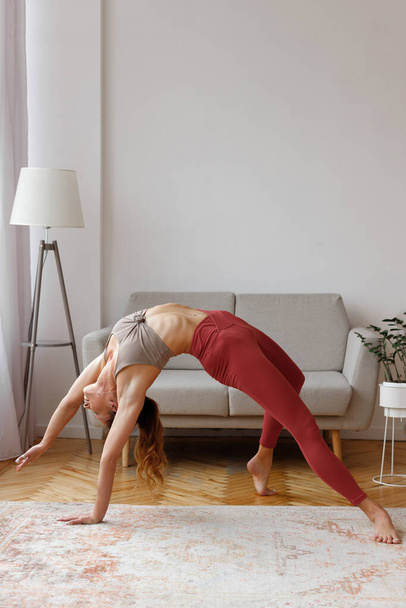 Frau posiert morgens in Bridge Yoga-Pose zu Hause - Foto, Bild