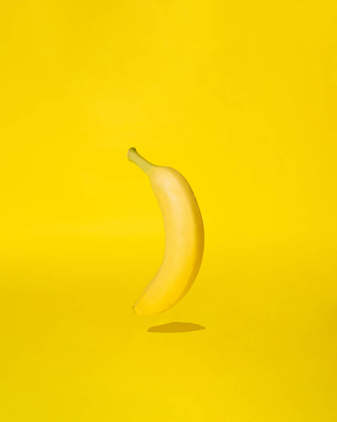 жовтий банан на сонячно-жовтому фоні. барвиста концепція абстрактного мистецтва
 - Фото, зображення