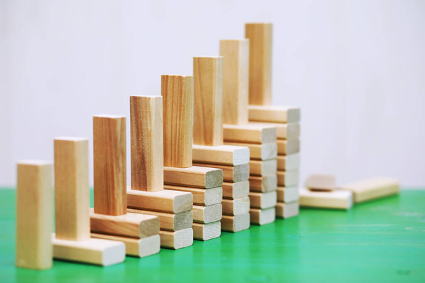 Stockholzblock auf gestapelten quadratischen Holzklötzen stehend, abstraktes Hintergrundkonzept von Gewinnen, Erfolg, Herausforderung, Schritt an die Spitze. - Foto, Bild