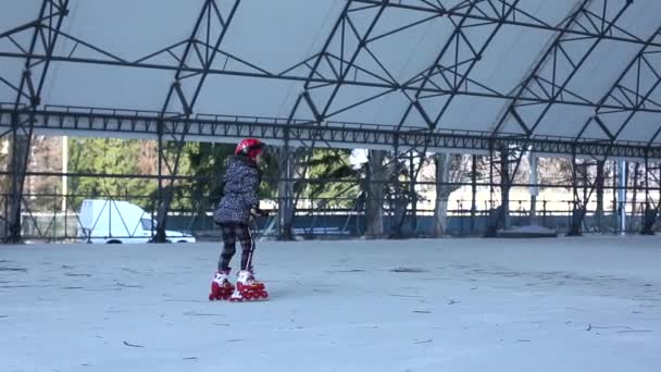 Cute Little Girl Wearing Protection Pads and Helmet Roller Skating near a Playground. Slow Motion. Childhood, Activities and Healthy Lifestyle Concept. - Footage, Video