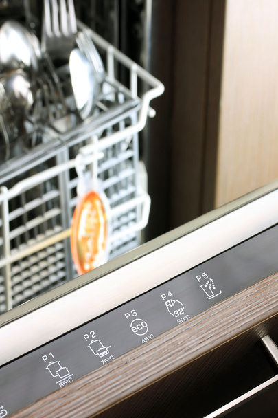 Painel de controle da máquina de lavar louça na frente da cesta de garfo e colher
 - Foto, Imagem