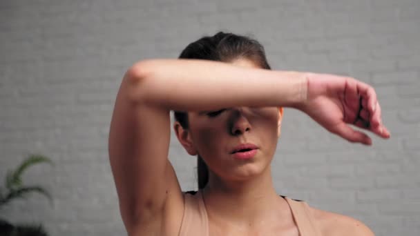 Спортивна сильна жінка витирає піт від обличчя після інтенсивних вправ
 - Кадри, відео