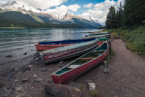 Colorful boats by Maligne lake, with Samson peak, Maligne mountain and Mount Paul in the background. Summer in Maligne valley of Jasper National Park, Alberta, Canada. - Photo, Image