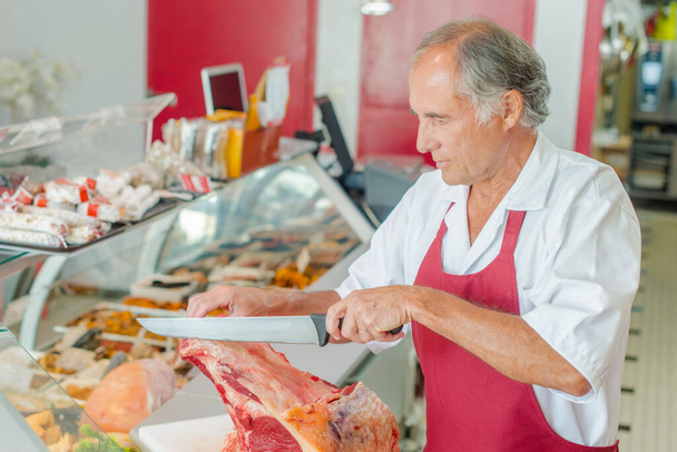 a butcher is cutting meat - Zdjęcie, obraz