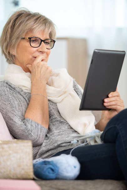 senior woman with eyeglasses browsing on digital tablet - Zdjęcie, obraz
