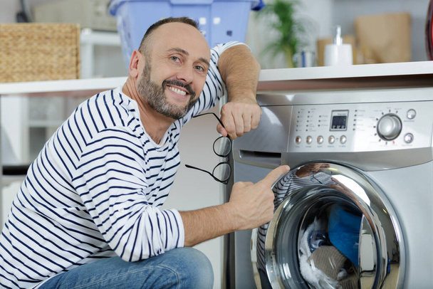 man pointing at washing machine - Valokuva, kuva