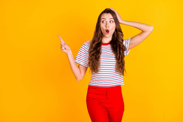 Portrait of attractive amazed stunned girl demonstrating copy space new novelty ad advert isolated over bright yellow color background - Zdjęcie, obraz