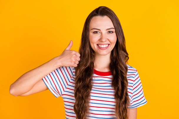 Πορτρέτο της ελκυστικής χαρούμενο κορίτσι δείχνει μικρογραφία σύμβολο δροσερό διαφήμιση συμφωνούν απομονωμένη πάνω από φωτεινό κίτρινο χρώμα φόντο - Φωτογραφία, εικόνα