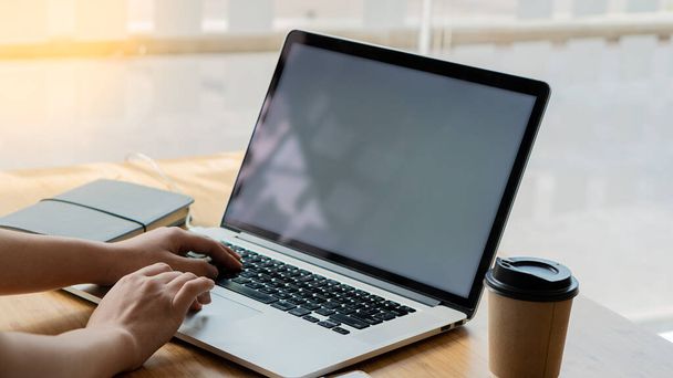 Uma jovem mulher sentada em um café e usando um smartphone em uma mesa com um laptop Jovens mulheres navegam no blog de bate-papo na internet - Foto, Imagem