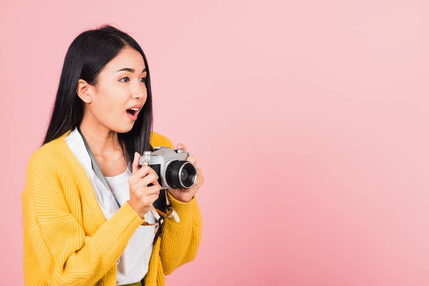 Attractive happy Asian portrait lifestyle beautiful young woman excited smiling photographer holding retro vintage photo camera ready to shoot isolated on pink background, tourism and vacation concept - Zdjęcie, obraz