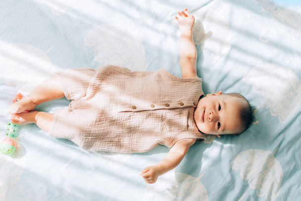 Dětská adopce a in vitro hnojení IVF. Asijské dítě leží na posteli. Péče o novorozence. - Fotografie, Obrázek