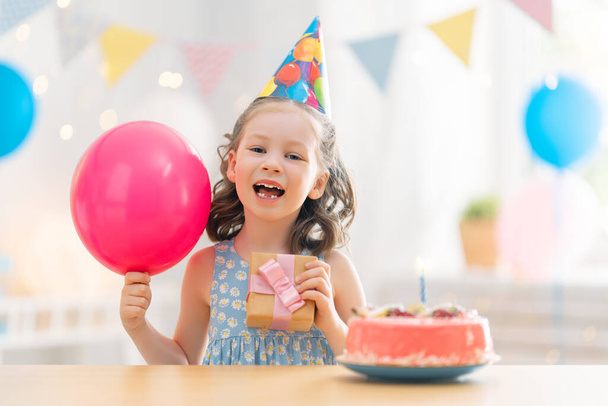 The kid is blowing out the candles on the cake. Child is celebrating birthday. - 写真・画像