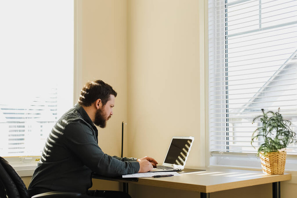 Hombre gerente sentado en el escritorio y el uso de ordenador portátil en el gabinete. - Foto, Imagen