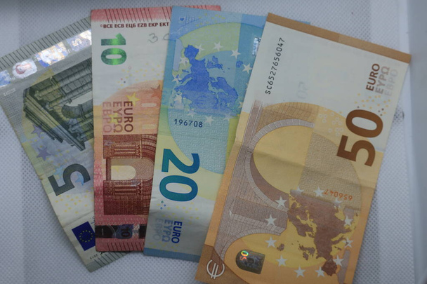 τραπεζογραμμάτια ευρώ διαφόρων ονομαστικών αξιών τοποθετημένα σε λευκό φόντο σε σχήμα ανεμιστήρα - Φωτογραφία, εικόνα